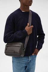 Profile view of model wearing the Oroton Ethan Pebble Camera Cross Body in Bitter Chocolate and Premium pebble leather for Men . IP:2