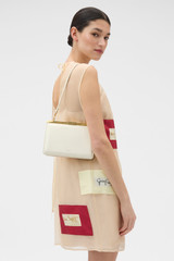 Profile view of model wearing the Oroton Icon Clutch in Clotted Cream and Premium embossed leather for Women .