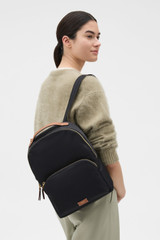 Profile view of model wearing the Oroton Lilly Nylon Backpack in BLACK/COGNAC and Nylon fabric for Women .