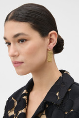 Profile view of model wearing the Oroton Mara Tassel Earrings in Worn Gold and Premium brass material for Women .