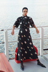Profile view of model wearing the Oroton Vintage Label Skirt in Black and 100% silk twill fabric for Women .