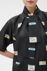 Profile view of model wearing the Oroton Vintage Label Blouse in Black and 100% silk twill fabric for Women .