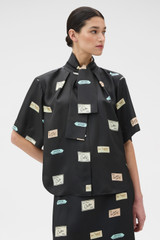 Profile view of model wearing the Oroton Vintage Label Blouse in Black and 100% silk twill fabric for Women .