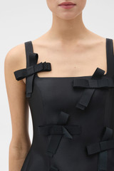 Profile view of model wearing the Oroton Bow Detail Mini Dress in Black and 85% polyester and 15% silk blend fabric for Women .
