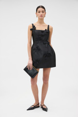 Profile view of model wearing the Oroton Bow Detail Mini Dress in Black and 85% polyester and 15% silk blend fabric for Women .