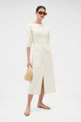Profile view of model wearing the Oroton Button Detail Dress in Soft Cream and 100% heavyweight linen fabric for Women .