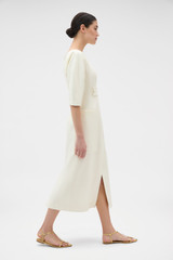 Profile view of model wearing the Oroton Button Detail Dress in Soft Cream and 100% heavyweight linen fabric for Women .