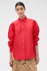 Profile view of model wearing the Oroton Satin Overshirt in Poppy and 85% polyester and 15% silk blend fabric for Women .