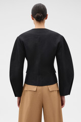 Profile view of model wearing the Oroton Sculpture Jacket in Black and 100% heavyweight linen fabric for Women .