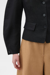Profile view of model wearing the Oroton Sculpture Jacket in Black and 100% heavyweight linen fabric for Women .