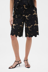 Profile view of model wearing the Oroton Poppy Lace Short in Black and 100% polyester fabric for Women .