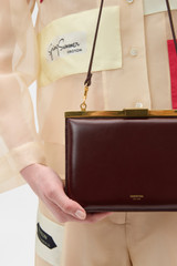 Profile view of model wearing the Oroton Icon Clutch in Copper and Premium smooth leather for Women .