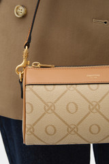 Profile view of model wearing the Oroton Harvey Signature Baguette Crossbody in Stone/Tan and Nylon canvas base cloth material with PVC coating (70% PVC, 30% polyester) for Women .