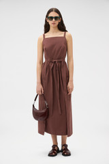 Profile view of model wearing the Oroton Cotton Apron Dress in Chocolate and 100% cotton poplin fabric for Women .