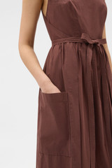 Profile view of model wearing the Oroton Cotton Apron Dress in Chocolate and 100% cotton poplin fabric for Women .