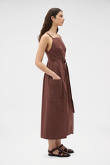 Profile view of model wearing the Oroton Cotton Apron Dress in Chocolate and 100% cotton poplin fabric for Women .