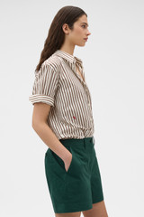 Profile view of model wearing the Oroton Alfie Carpenter Short in Helm Green and Crafted from cotton twill  for Women .