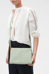Profile view of model wearing the Oroton Dorit Small Day Bag in Rosemary and Premium pebble leather  for Women .