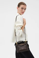Profile view of model wearing the Oroton MICA WORKMANSHIP MINI BOWLER in Dark Chocolate and Premium smooth leather with a refined finish for Women .