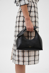 Profile view of model wearing the Oroton Myrtle Mini Bag in Black and Premium smooth leather for Women .