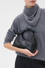 Profile view of model wearing the Oroton Myrtle Mini Bag in Black and Premium smooth leather for Women .