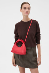 Profile view of model wearing the Oroton Myrtle Mini Bag in Market Red and Premium smooth leather for Women .