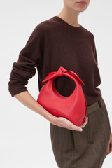Profile view of model wearing the Oroton Myrtle Mini Bag in Market Red and Premium smooth leather for Women .