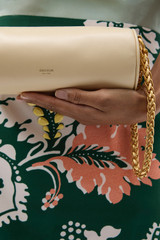 Profile view of model wearing the Oroton Romy Barrel Bag in Honey Peach and Premium smooth leather for Women .