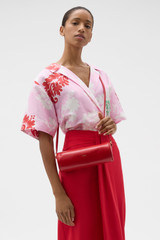 Profile view of model wearing the Oroton Romy Barrel Bag in Market Red and Premium smooth leather for Women .