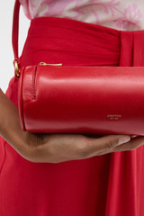 Profile view of model wearing the Oroton Romy Barrel Bag in Market Red and Premium smooth leather for Women .