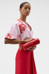 Profile view of model wearing the Oroton Romy Barrel Bag in Market Red and Premium smooth leather for Women .