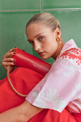 Profile view of model wearing the Oroton Romy Barrel Bag in Market Red and Premium smooth leather for Women .