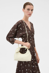 Profile view of model wearing the Oroton Myrtle Mini Bag in Vanilla Bean and Premium smooth leather for Women .