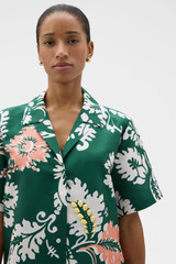 Profile view of model wearing the Oroton Cabana Floral Camp Shirt in Helm Green and 100% silk dupion fabric for Women .