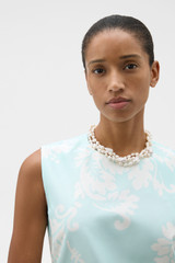 Profile view of model wearing the Oroton Vera Pearl Necklace in Pearl and Brass base for Women .