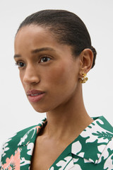 Profile view of model wearing the Oroton Coral Medium Hoop in Worn Gold and Brass base for Women .