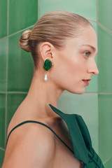 Profile view of model wearing the Oroton Cove Earrings in Helm Green/Worn Gold and Brass base for Women .