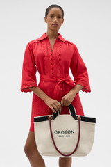 Profile view of model wearing the Oroton Skipper Tote in Natural and Premium canvas material for Women .