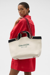 Profile view of model wearing the Oroton Skipper Tote in Natural and Premium canvas material for Women .