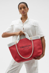 Profile view of model wearing the Oroton Skipper Tote in Cherry and Premium canvas material for Women .