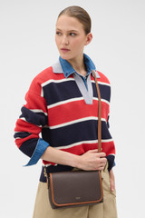 Profile view of model wearing the Oroton Laura Flap Over Crossbody in Coffee Bean/Cognac and Premium pebble leather for Women .