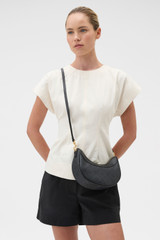Profile view of model wearing the Oroton Harvey Signature Crescent Shoulder Bag in Black and Nylon canvas base cloth material with PVC coating (70% PVC, 30% polyester) for Women .