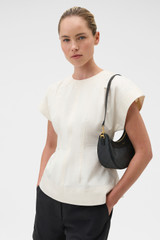Profile view of model wearing the Oroton Harvey Signature Crescent Shoulder Bag in Black and Nylon canvas base cloth material with PVC coating (70% PVC, 30% polyester) for Women .