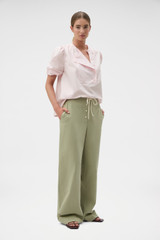 Profile view of model wearing the Oroton Weekend Pull On Pant in Soft Sage and 100% cotton fabric for Women .
