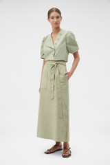 Profile view of model wearing the Oroton Snap Detail Skirt in Soft Sage and 100% cotton fabric for Women .