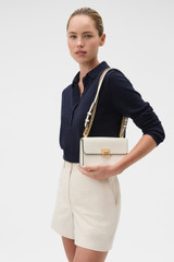 Profile view of model wearing the Oroton Yvette Small Clutch Bag in Cream and Premium textured leather for Women .