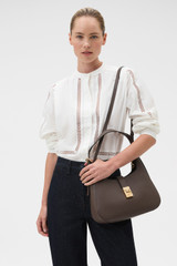 Profile view of model wearing the Oroton Yvonne Large Baguette in Coffee Bean and Premium pebble leather for Women .