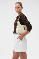 Profile view of model wearing the Oroton Yvonne Large Baguette in Cream and Premium pebble leather for Women .