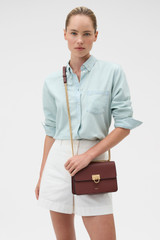 Profile view of model wearing the Oroton Yvette Medium Clutch Bag in Russet and Premium textured leather for Women .