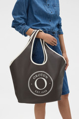Profile view of model wearing the Oroton Kaia Crescent Shopper Tote in Coffee Bean/Cream and Canvas material for Women .